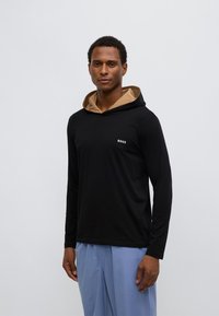 Must pika varrukatega kapuutsiga pusa, millel on beež sisetükk ja väike valge "BOSS" logo rinnal. Lõdvestunud istuvus, pehme kangas.