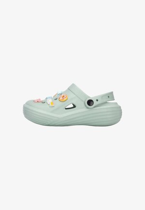 Zueco azul claro tipo slip-on con agujeros de ventilación, correa ajustable en el talón y encantos decorativos coloridos adheridos a la parte superior.
