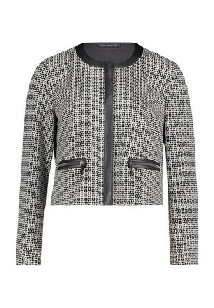 Veste noir et blanc recadrée avec un motif en grille texturé. Caractéristiques : col rond, fermeture éclair frontale et deux poches zippées.