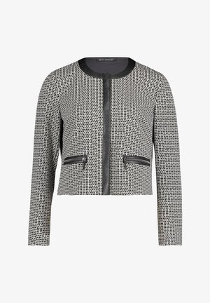 Veste noir et blanc recadrée avec un motif en grille texturé. Caractéristiques : col rond, fermeture éclair frontale et deux poches zippées.