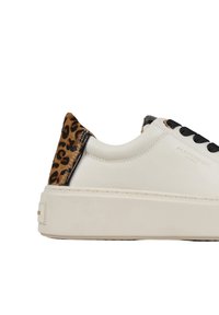 Sneaker bianco in pelle con un accento a stampa leopardata sul tallone. Presenta lacci neri e una suola spessa bianca. Texture complessivamente liscia.