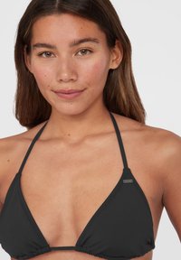 Svart triangelbikinitopp med tunna justerbara remmar, veckad detalj längs kanterna och en liten logotypaccent på ena sidan.