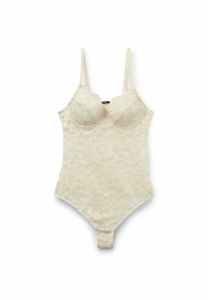 Spitzenbodysuit in Off-White mit verstellbaren Trägern, ausgestattet mit einem gewellten Ausschnitt und einer taillierten Form, die für eine glatte Silhouette sorgt.