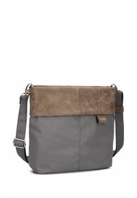 Bolso de hombro de tela gris con tapa superior de ante marrón, asa ajustable, metal brillante y una etiqueta de marca sutil en el lado.