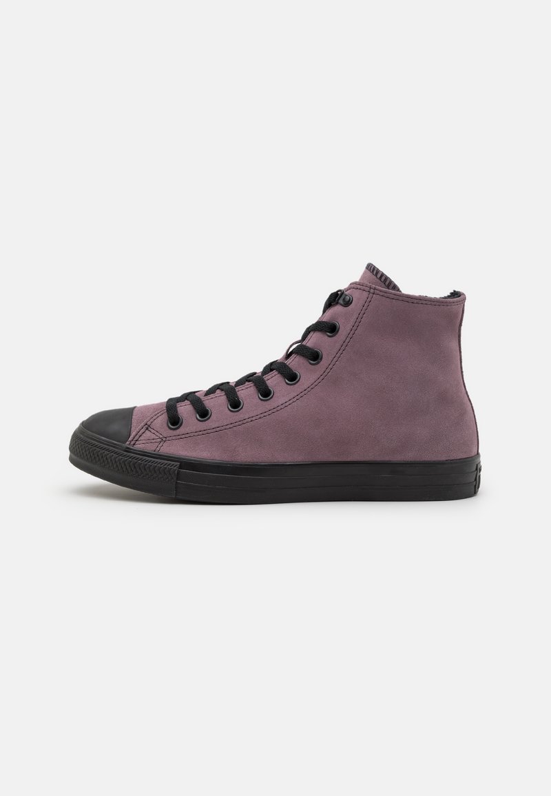 Lila hög sneaker med en texturerad mockaöverkonstruktion, svart gummikappa vid tån, platta snören och en svart gummisula.