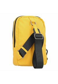 Bolso cruzado amarillo de nailon con forma rectangular, que presenta una correa ajustable negra, herrajes plateados y doble cierre con cremallera.