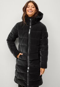 Zwarte pufferjas met een capuchon, voorzien van een verticaal gequilt patroon, een ritssluiting aan de voorkant en zijzakken. Gladde, glanzende stoftextuur.