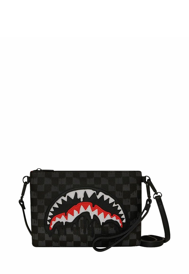 Borsa a tracolla nera rettangolare con motivo a scacchiera e design stilizzato di bocca di squalo in bianco e rosso sulla parte frontale.