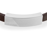 Bracciale in pelle marrone con chiusura rettangolare in argento lucido, caratterizzata da scanalature diagonali e incisione del logo "Calvin Klein".