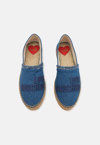 Džinsinės espadrilės su apvaliu pirštu, mėlyna medžiaga, jūrinė bazė ir tamsiai mėlyna siuvinėta "LOVE MOSCHINO" ant viršaus. Raudona širdies logo viduje.
