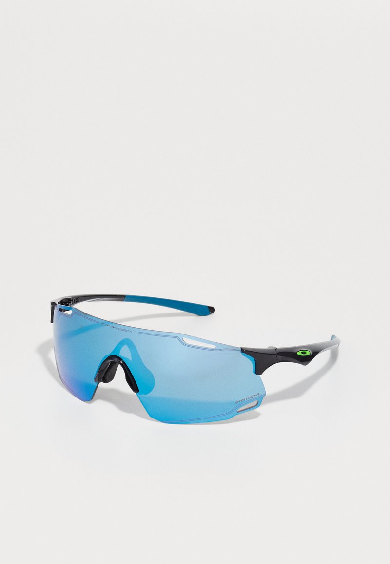 Sportssolbriller med blå speilglass, svart og blå ramme, aerodynamisk design og merkbar grønn aksent på templene.