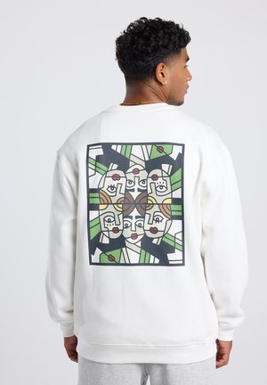 Sweat-shirt blanc avec un design graphique audacieux et multicolore au dos, représentant des visages avec des formes et des lignes contrastées.