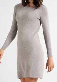 Hellgraues, langärmeliges Strickkleid mit rundem Ausschnitt, schmaler Passform, gerippten Bündchen und glatter Textur. Verfügt über einen knielangen Saum.