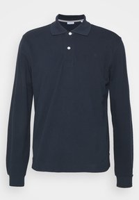 Polo a maniche lunghe di colore blu navy realizzato in cotone, con colletto, patta con due bottoni e un logo discreto sul petto.