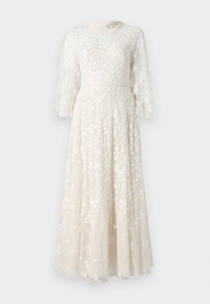 Robe longue en crème clair, brodée de fleurs, avec des manches en tulle volantées et un corsage ajusté, se déployant en une jupe évasée.