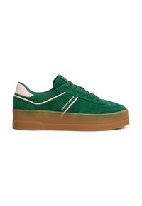 Grønn semsket sneaker med rosa aksent på hælen, med hvit logo og en tykk gummisåle. Rund tå og snøring.