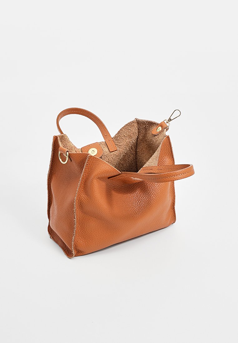 Braune Lederhandtasche mit strukturiertem Außenmaterial, weichem Innenraum, zwei Griffen und einem Verschluss mit Klinke. Abgerundete Form mit sichtbaren Nähten.