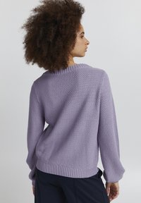 Lila gestrickter Pullover mit strukturiertem Muster, geripptem Kragen und Bündchen. Lässige Passform mit überschnittenen Schultern und einem subtilen Glanz.