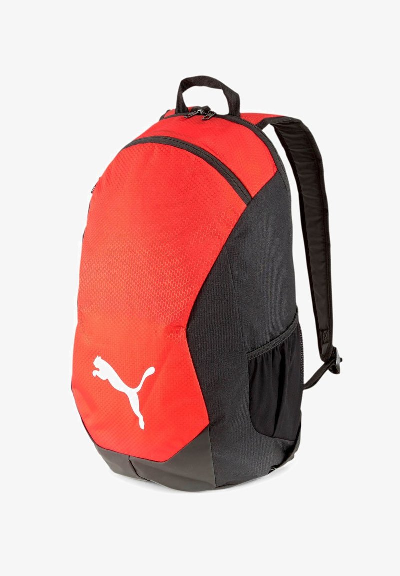 Sac à dos rouge et noir, avec une partie supérieure texturée et une partie inférieure lisse, orné d'un logo blanc proéminent et de bretelles ajustables.
