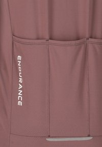 Wijnkleurig sporttop van een zachte, textuurstof. Bevat drie achterzakken en een witte "ENDURANCE" logo aan de zijkant.