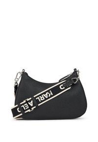 Black leather handbag with a curved shape, featuring a textured surface and a contrasting black and white strap with "KARL" lettering.
