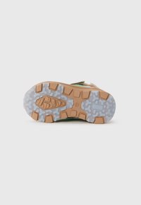Suela de zapato con un patrón de agarrre rugoso y multidireccional; materiales de goma translúcida en gris y marrón; presenta acentos acolchados y texturizados.