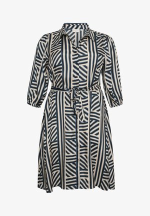 Beige värvi nupuga särk-kleit, millel on julged sinised ja mustad triibud, pikad varrukad ja vöödiga talje, et luua näoväline ilme.