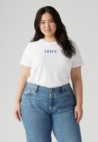 White cotton t-shirt with "L.E.V.I.'S" in blue lettering, paired with high-waisted, light-wash denim jeans featuring classic stitching and pockets.