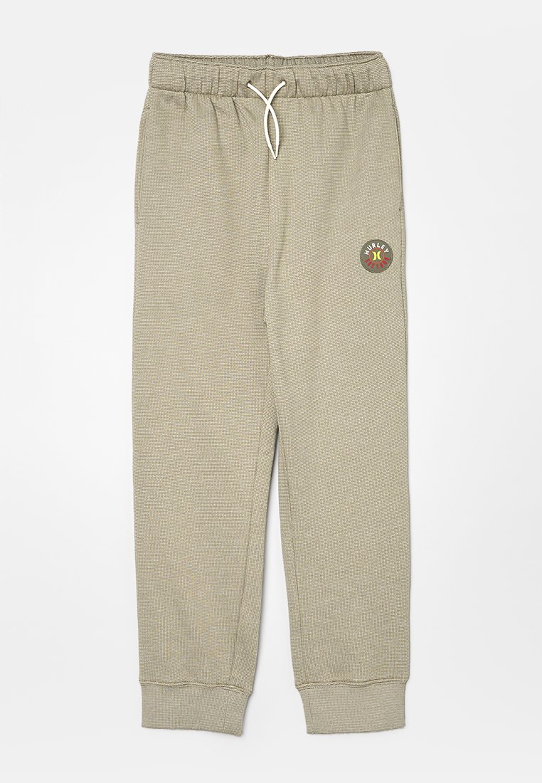 Grijze geribbelde joggingbroek met een elastische tailleband en een trekkoord, met een ronde logo patch op de bovenste dij. Verstevigd bij de enkels.
