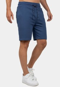 Navyblauwe sportshorts van zachte stof, met een elastische tailleband met trekkoord, zijzakken en een getailleerd ontwerp.