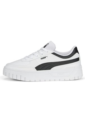 Baskets blanches avec une bande texturée noire, dotées d'une semelle blanche épaisse, d'un bout rond et d'un design à lacets. Logo PUMA sur le côté.