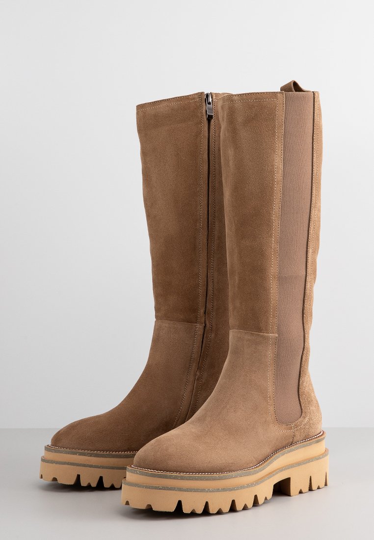 Suede-Stiefel bis zum Knie in Hellbraun mit robuster Gummisohle. Ausgestattet mit einem seitlichen Reißverschluss und einem elastischen Einsatz für Flexibilität. Texturierte Oberfläche.