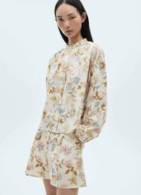 Floral blouse and shorts set featuring a light cream fabric, pastel-colored flowers, relaxed fit, and gathered neckline detail.