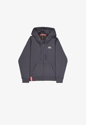 Sivo zip-up kapuča s kapuco na vrvico, sprednjimi žepi, rebrastimi manžetami in logotipom na prsih. Tkanina se zdi mehka in teksturirana.