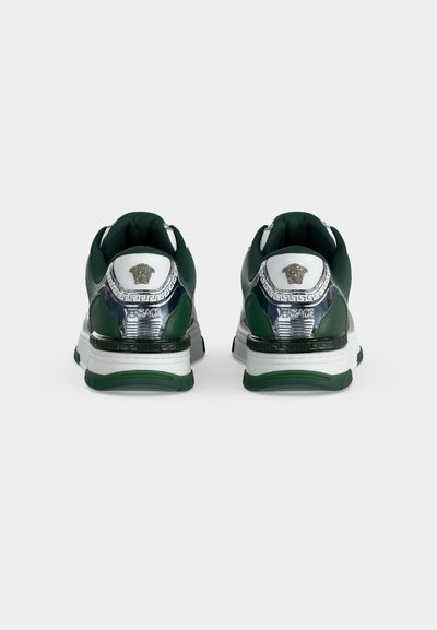 Paire de baskets vertes et blanches avec des accents argentés, logo Méduse et marquage Versace, vue de dos sur un fond blanc uni.