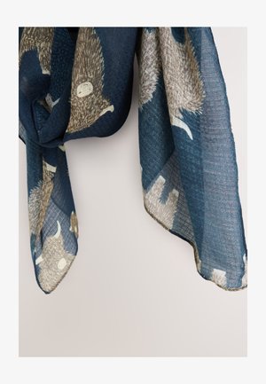 Tamsiai mėlynas šalikas su tekstūruotu audimu, ant kurio pavaizduotas šviesių spalvų gyvūnų su ragais raštas. Kraštai užbaigti ir šiek tiek suirę.