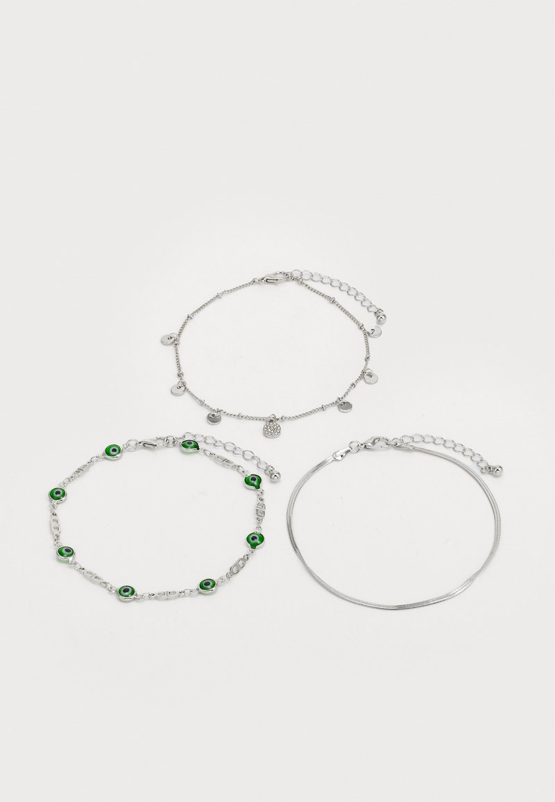 Tres pulseras de plata: una con cuentas de ojo verde, otra con charms circulares, y una cadena lisa y suave. Varios estilos y longitudes de cadena.