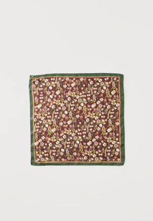 Foulard carré avec bordure verte et motif floral dense rose, blanc et vert sur fond marron.