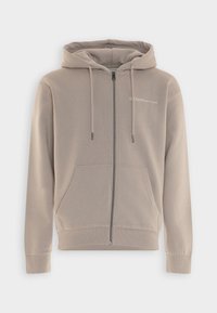 Sudadera con cremallera en color beige, hecha de una tela suave. Cuenta con capucha con cordón, bolsillos delanteros, puños acanalados y un pequeño logo impreso en el pecho.