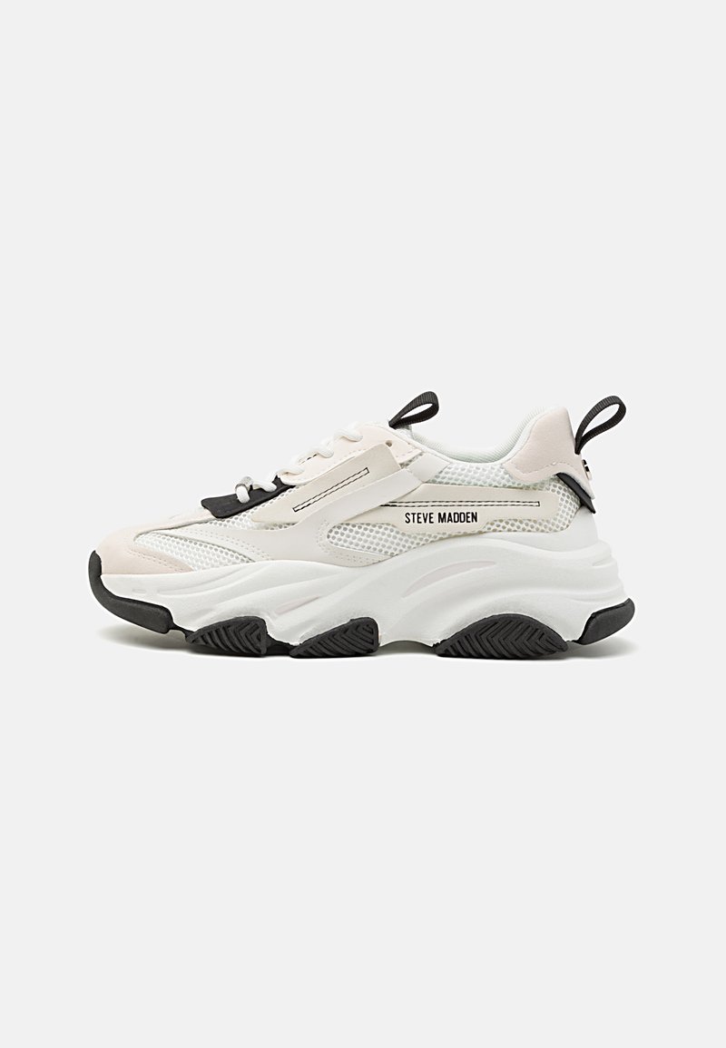 Chunky sneakers featuring a mesh and leather upper in light beige and white, with black accents, thick rubber sole, and lace-up design.