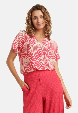 Kortom, een blouse met korte mouwen en V-hals in een roze en witte golvend patroon, gemaakt van lichte stof, gecombineerd met textuur roze hoge taille broek.