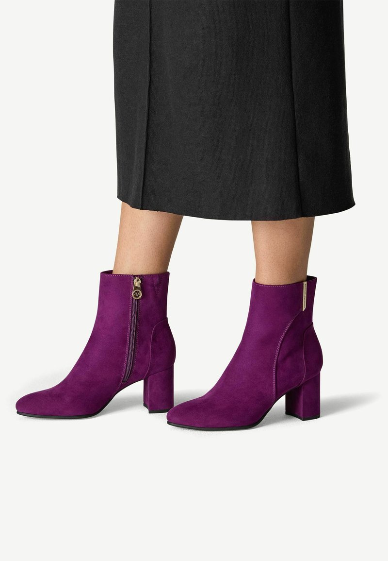 Fialové semišové kotníkové boty s kulatou špičkou, blokovým podpatkem a bočním zipem. Hladký povrch a elegantní design vhodný pro různé outfity.