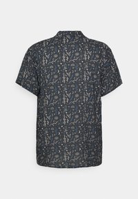 Camicia a maniche corte in tessuto blu scuro con un motivo giocoso e multicolore di forme astratte e simboli su tutta la superficie.