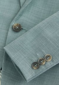 Lichtblauwe gestructureerde blazer mouw met drie gemarmerde knopen en zichtbare bijpassende blazer voorknop.