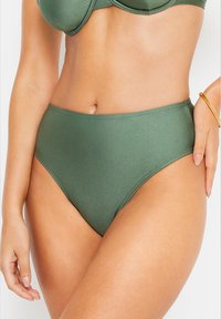 Aukštos juosmens bikini tipo apatiniai, pagaminti iš lygaus, žalio audinio. Savybės: iškeltas juosmens kraštas, be siūlių dizainas ir minimalus siuvimo detalių kiekis.