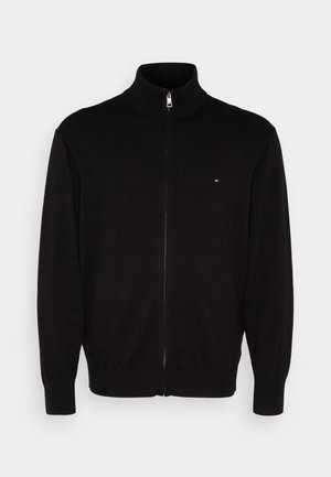 Zwart ritsvest, gemaakt van zachte stof, met een hoge kraag, lange mouwen en een klein logo-accent op de borst.