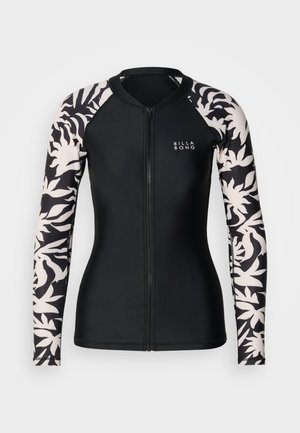 Svart långärmad rashguard med dragkedja, vita och svarta ärmar med tropiskt lövmönster och liten "Billabong"-logotyp på bröstet.