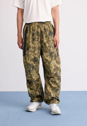 Camo-patroon cargobroek in groentinten, met een elastische tailleband, zijritszakken en iets taps toelopende benen.
