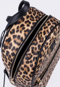 Zaino rotondo con stampa leopardata, dettagli in pelle nera, doppia chiusura a zip e particolari in oro. Tessuto morbido con motivo a macchie.