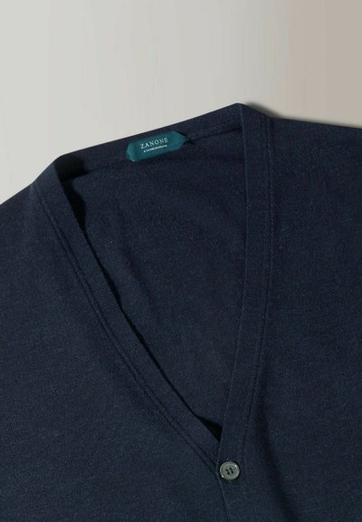 Pull en v bleu marine en matière tricot douce, doté d'une fermeture à bouton et d'une étiquette "ZANONE" au niveau du col.